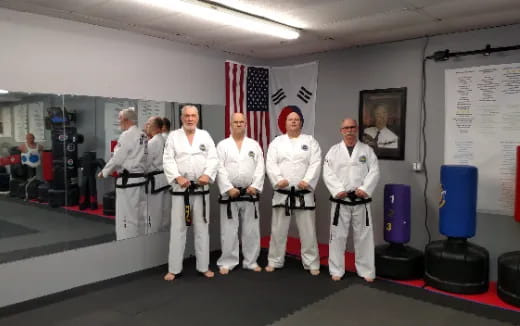 a group of people in white karate uniforms standing on a stage