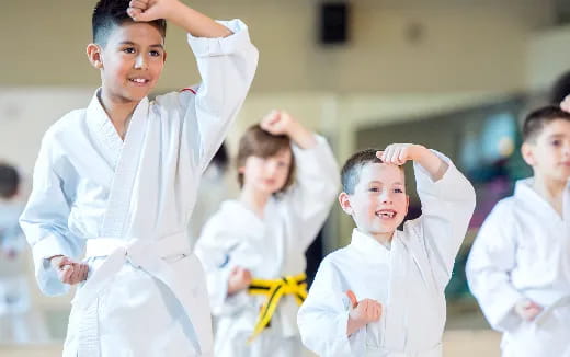 a group of children in white karate uniforms