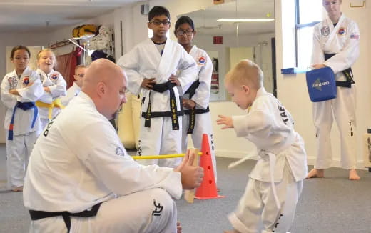 a person in a karate uniform with a boy in a white shirt