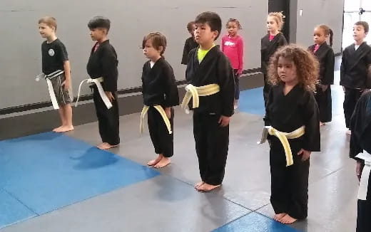 a group of children in black karate uniforms