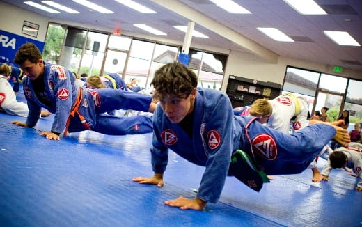 a group of people in blue karate uniforms on a mat