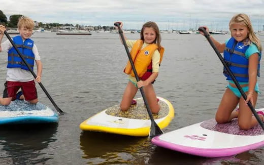 a group of kids on paddle boards