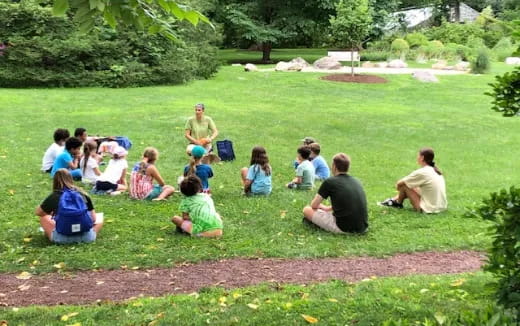 a group of people sitting on the grass