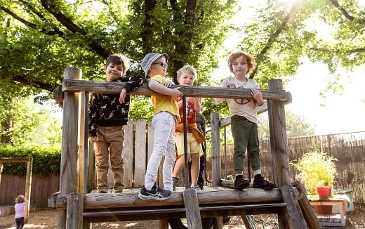 a group of kids standing on a wooden fence