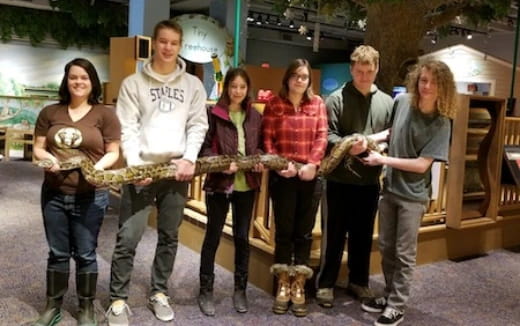 a group of people holding a snake