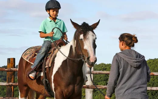 a person and a child riding a horse