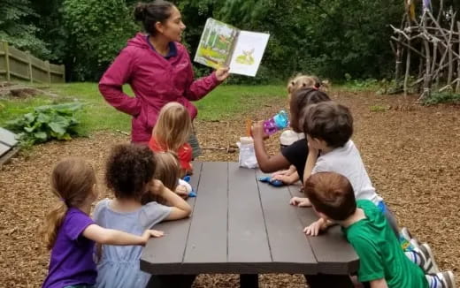 a person teaching children how to use a table