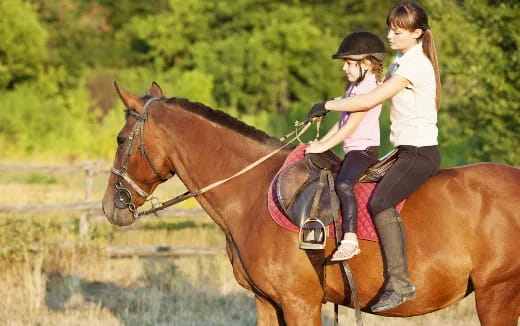 a couple of girls riding horses