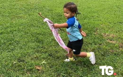 a girl running in a grassy area