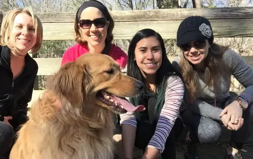 a group of people posing with a dog