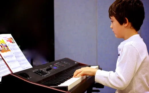 a young man playing a piano