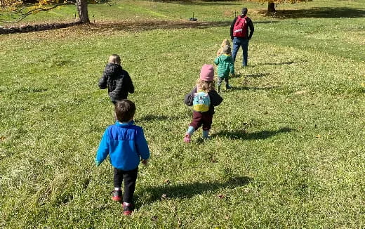 a group of children walking on grass