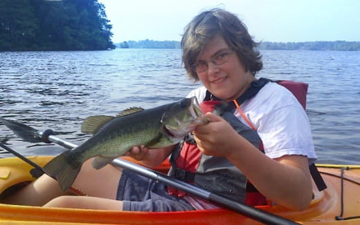 a person in a boat holding a fish