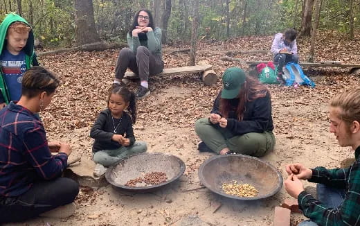 a group of people sitting on the ground eating food