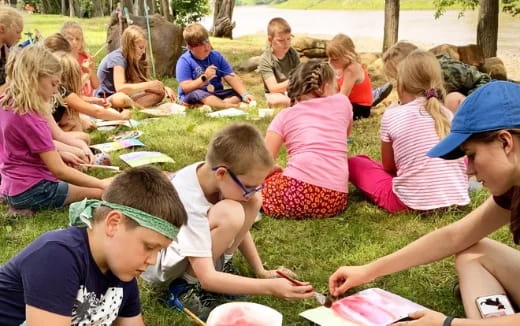 a group of children sitting on the grass