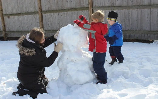 a group of kids playing with a snowman