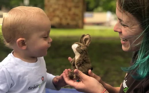 a person and a baby petting a rabbit