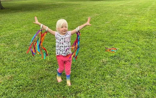 a little girl playing with a kite