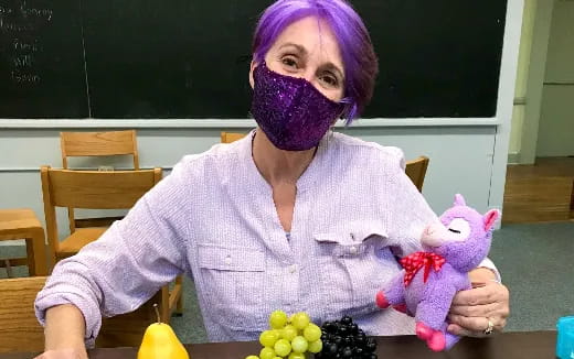 a person with purple hair holding a stuffed animal