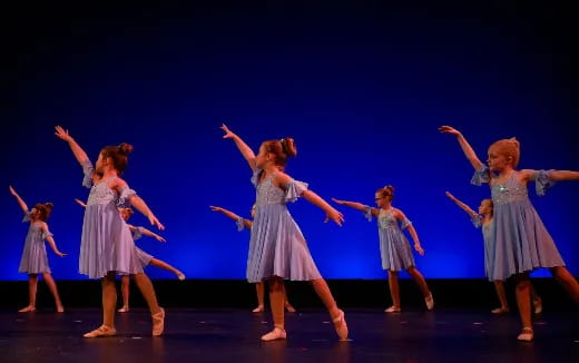 a group of girls dancing on a stage