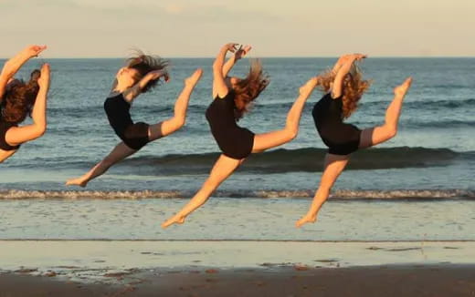 a group of women doing yoga on a beach