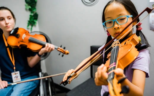 a couple of kids playing violin