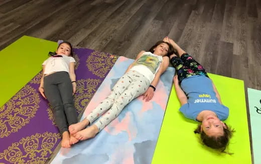 a group of girls lying on a colorful pillow