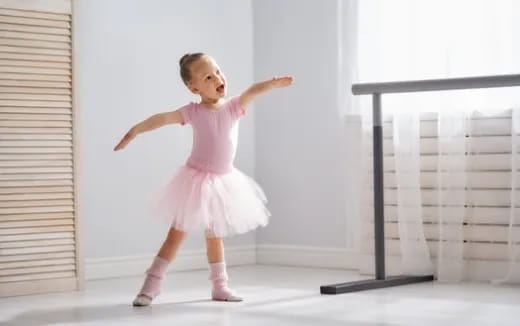 a girl in a pink dress dancing
