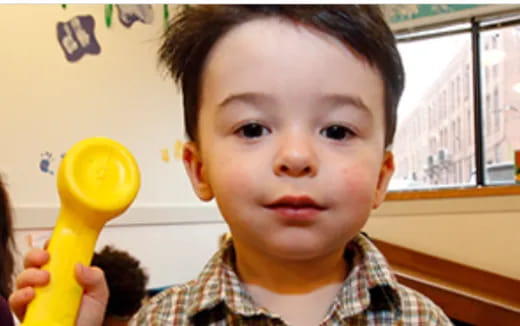 a child holding a yellow toy