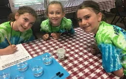 a group of young girls sitting at a table