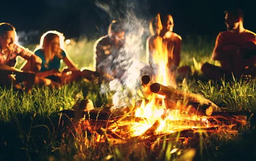 a group of people sitting around a fire