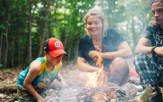 a person and a boy sitting next to a fire