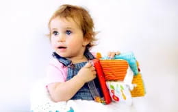 a baby holding a basket