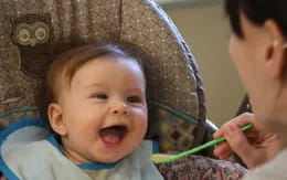 a baby with a green string around its neck