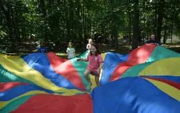 a girl jumping on a group of colorful tents