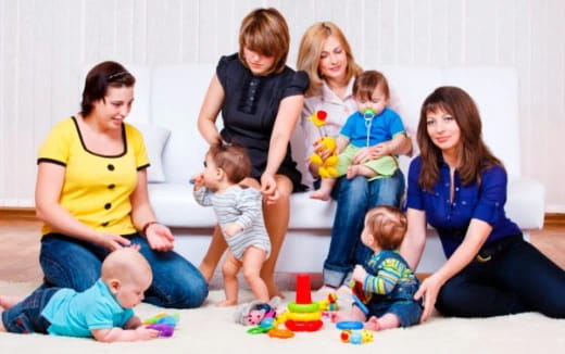 a group of people sitting on the floor with a baby