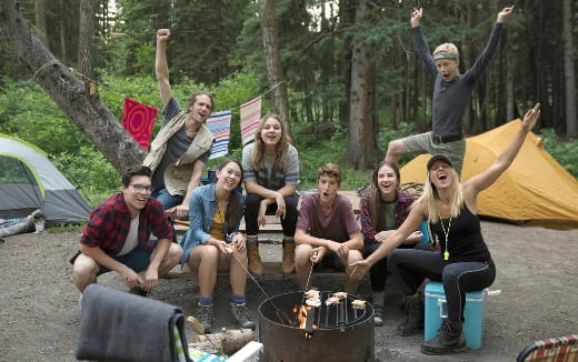 a group of people sitting on a campfire