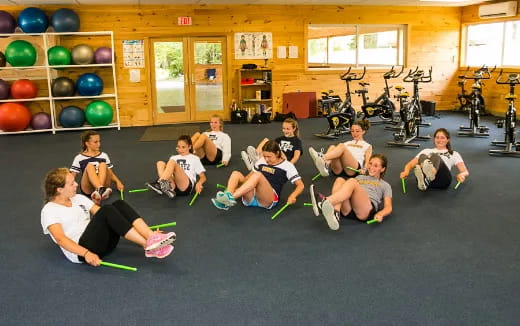 a group of people sitting on the floor in a gym