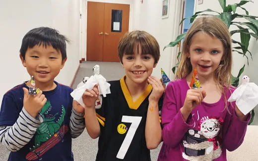 a group of children holding up a white object