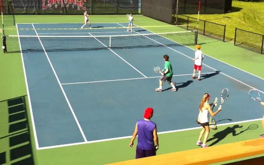 people playing tennis on a court