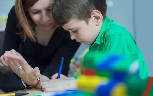 a person and a boy looking at a paper