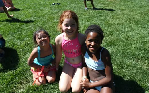 a group of girls sitting on grass