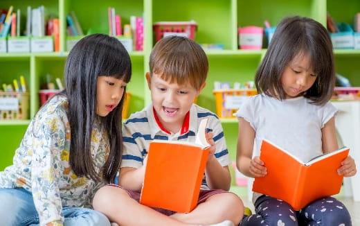 a group of children sitting on the floor reading books