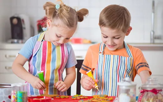 a couple of children making food