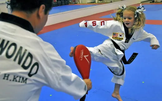 a man kicking a woman in the face with a red ball