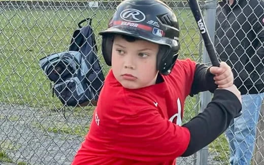 a young boy holding a baseball bat