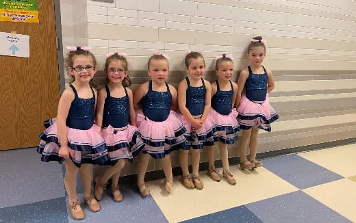 a group of girls in matching outfits