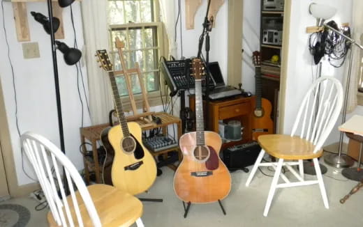 a room with guitars and chairs