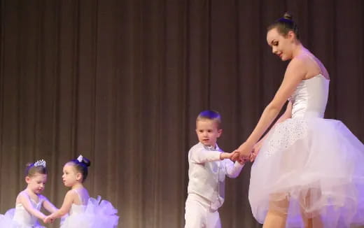 a person in a white dress and a group of children in a room