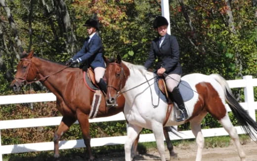 a couple of women riding horses